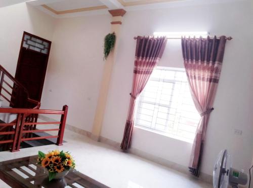a room with a window with curtains and a table at Cherry homestay in Ninh Binh