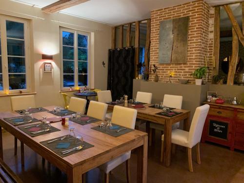 une salle à manger avec une table et des chaises en bois dans l'établissement Au Presbytère de Saigneville, à Saigneville