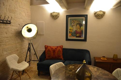 a living room with a blue couch and a table at Gatto Bianco Case d'Allora in Alberobello