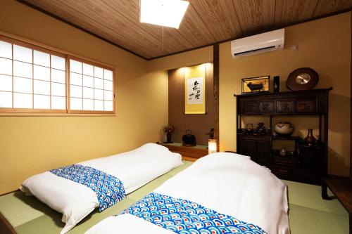 a room with two beds and a window at Shirakabanoyado - Nakamichi in Osaka