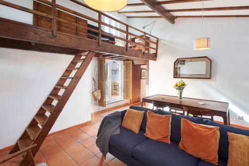 a living room with a blue couch and a loft at Casalinho Macieira in Azoia