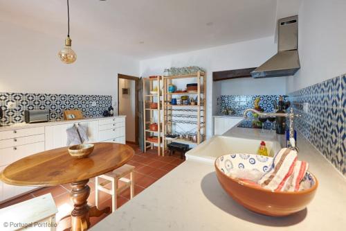 a kitchen with a wooden table and a table at Casalinho Macieira in Azoia