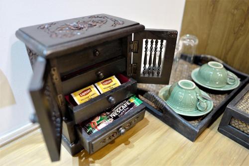 an old wooden box with a tea set on a table at Big Tree Old Town Hotel in Chiang Mai