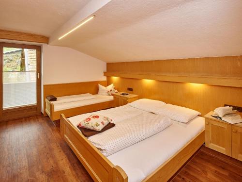 a bedroom with two beds and a window at Landhaus Fiegl in Sölden