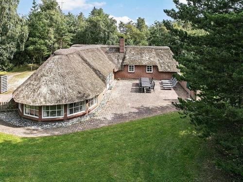 una casa con techo de paja y césped en 12 person holiday home in V ggerl se en Bøtø By