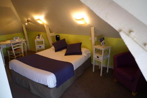 ベトンにあるLogis Hôtel De La Levéeのベッドと椅子付きの小さな部屋です。