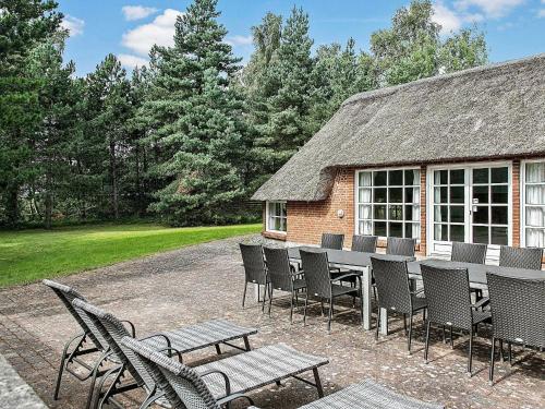 a patio with a table and chairs and a building at 12 person holiday home in V ggerl se in Marielyst