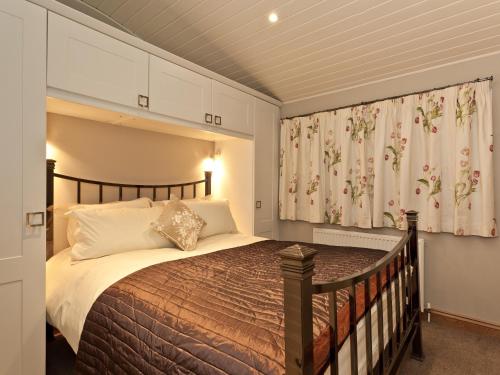 een slaapkamer met een groot bed en een gordijn bij Lodge on the Lake in Windermere