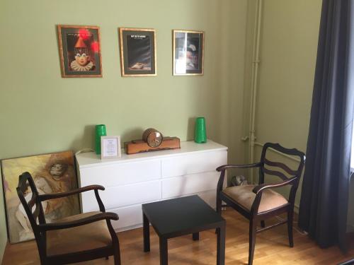 sala de estar con 2 sillas, tocador y mesa en Apartament PIĘKNA, en Varsovia