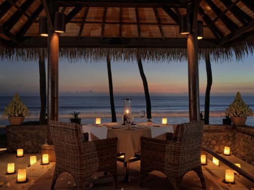 a table in a restaurant with a view of the ocean at The Legian Seminyak, Bali in Seminyak