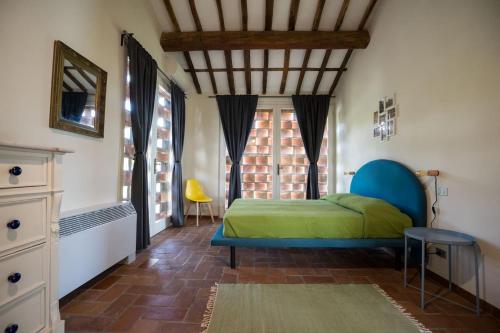 1 dormitorio con cama y ventana en Casale rinnovato immerso nella campagna con splendida piscina privata, en Capannori