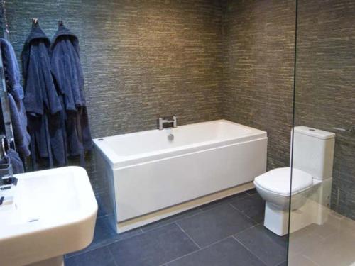 La salle de bains est pourvue d'une baignoire, de toilettes et d'un lavabo. dans l'établissement Yew Tree Cottage, à Coniston