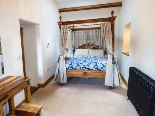 ein Schlafzimmer mit einem Himmelbett in der Unterkunft Yew Tree Cottage in Coniston