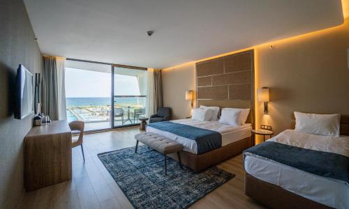 Cette chambre d'hôtel comprend deux lits et offre une vue sur l'océan. dans l'établissement Wave Resort - Ultra All Inclusive, à Pomorie