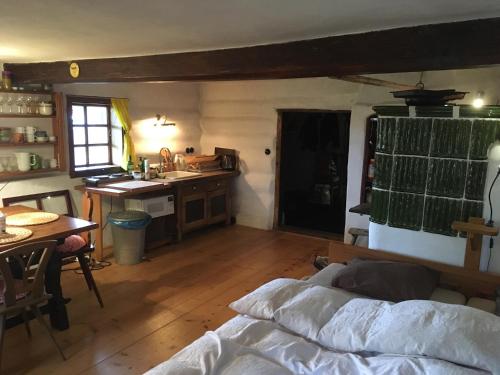 ein Schlafzimmer mit einem Bett und eine Küche mit einem Tisch in der Unterkunft Chalupa U Vincků in Stachy