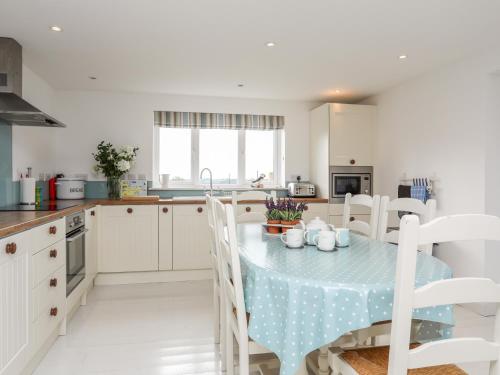 a kitchen with a table with a blue table cloth at Hafod, Llangoed in Llangoed
