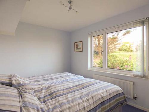 a bedroom with a bed and a window at Godolphin in Wadebridge