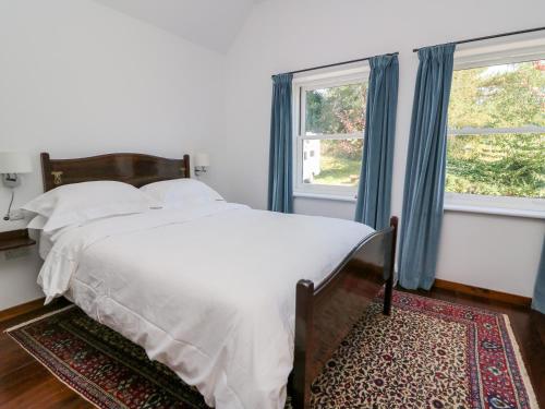 a bedroom with a bed and two windows at The Pheasantry in Builth Wells