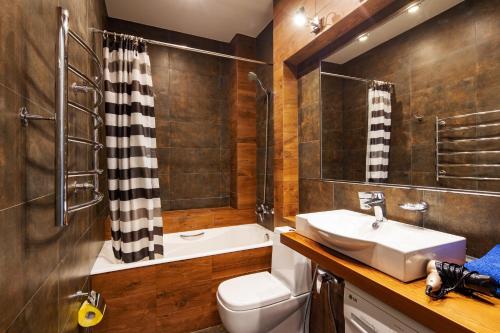 een badkamer met een wastafel, een toilet en een douche bij n-Joy Cinema in Novorossiejsk
