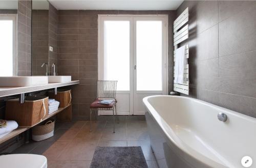 uma casa de banho com uma banheira, um lavatório e um WC. em Aux 4 Sardines T2 56m2 em Concarneau