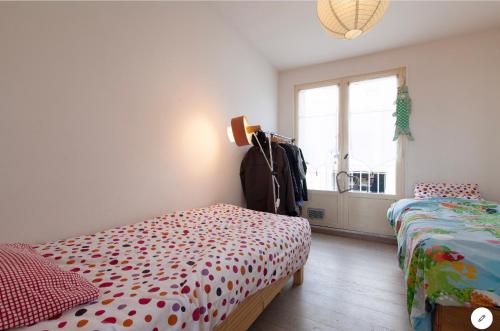 1 dormitorio con 2 camas y ventana en Aux 4 Sardines T2 56m2, en Concarneau