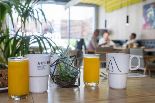 a table with two glasses of orange juice and two mugs at ARTIEM Madrid in Madrid