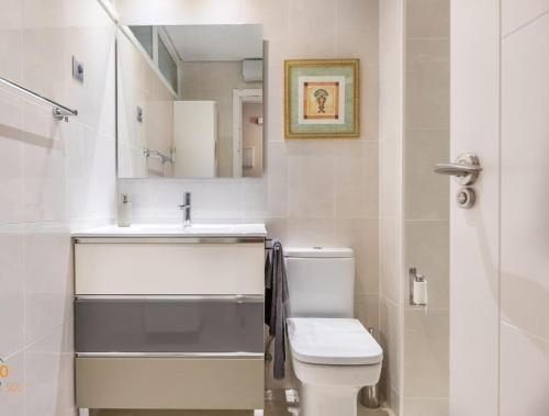 y baño con aseo, lavabo y espejo. en Fuengirola. Bonito apartamento en Paseo Marítimo. Espectaculares vistas al mar. Primera línea en Fuengirola