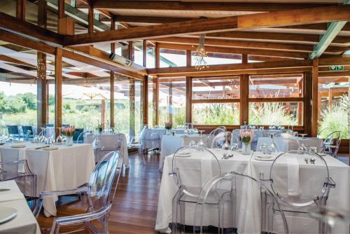 un salón de banquetes con mesas y sillas blancas en Forum Homini Boutique Hotel, en Krugersdorp