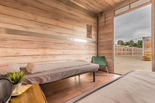 a room with two beds and a wall with wood at Oktoberfest Wiesn Camp Lodge in Munich