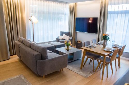 a living room with a couch and a table at Verde Apartments CENTRUM klimatyzacja in Koszalin