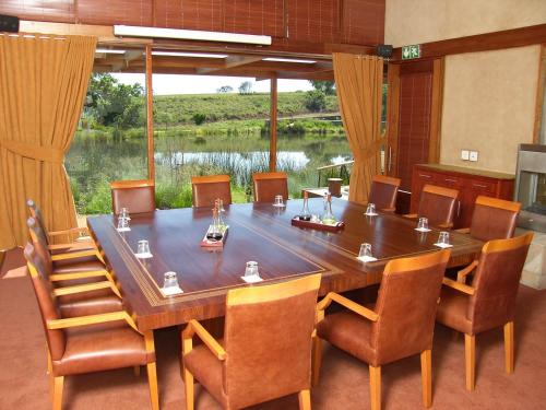 a conference room with a large wooden table and chairs at Forum Homini Boutique Hotel in Krugersdorp