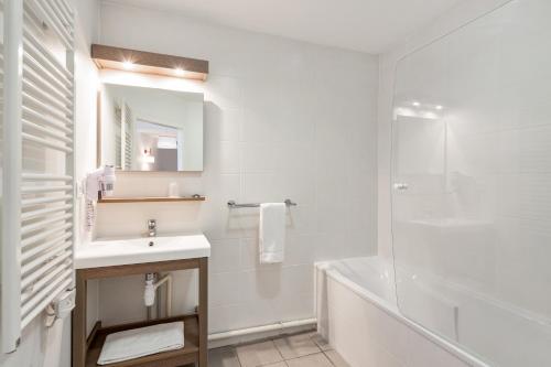 y baño blanco con lavabo y ducha. en Appart'City Confort Mulhouse en Mulhouse