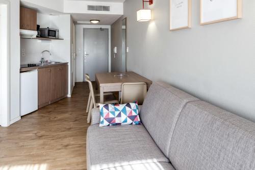 a living room with a couch and a table at Appart'City Confort Mulhouse in Mulhouse