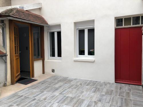 uma casa com uma porta vermelha e uma janela em Belle Place 89 Appartement em Auxerre