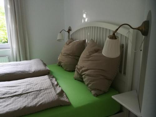 a room with a bed with two pillows and two lamps at Ferienwohnung Drabinski in Kiel