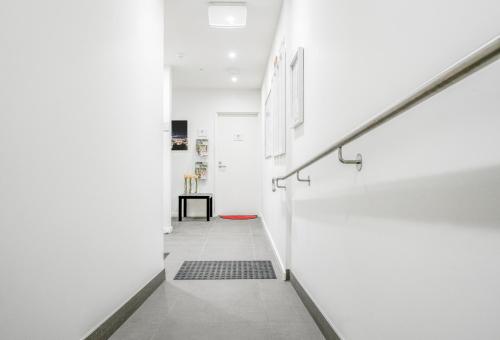 a hallway with white walls and a white staircase at U201 Brunswick Living Top floor Balcony Close to APT and CBD Free Wifi Tram at Doorstep in Melbourne