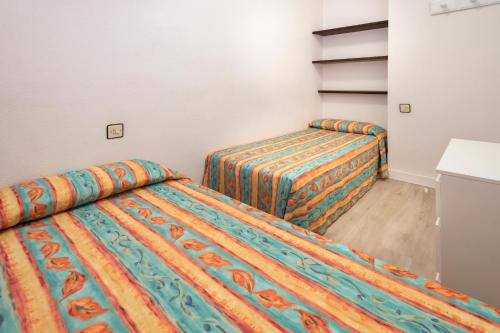 two beds in a small room with at Apartments Sorrabona in Pineda de Mar