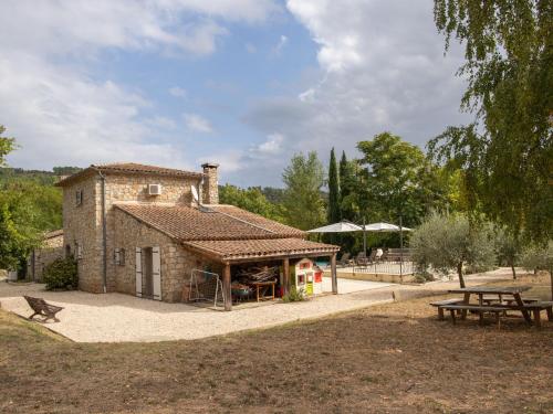 un pequeño edificio de piedra con una mesa y un banco en Magnificent villa in the south of the Ard che, en Sallelles