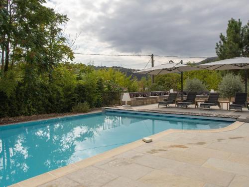 una piscina con sillas y sombrillas en un patio en Magnificent villa in the south of the Ard che, en Sallelles