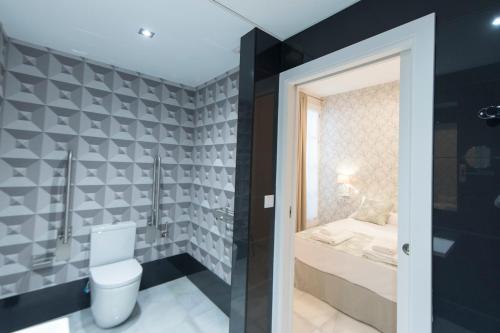 La salle de bains est pourvue de toilettes et d'un lavabo. dans l'établissement Céntriko Apartments Quintero 40, à Séville