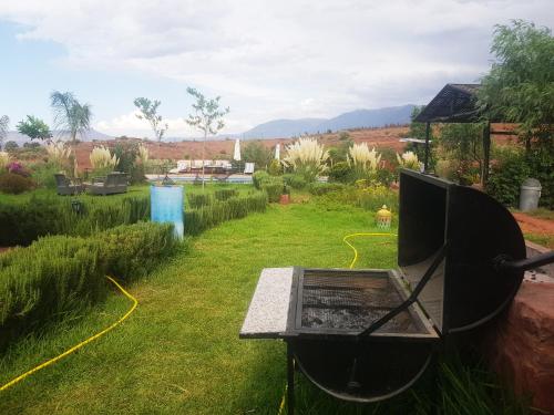 a garden with a table in the grass at Les Jardins Yasmina Bin el-Ouidane in Bine el Ouidane