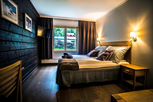 a bedroom with a large bed with a window at Eriksgårdens Fjällhotell in Funäsdalen