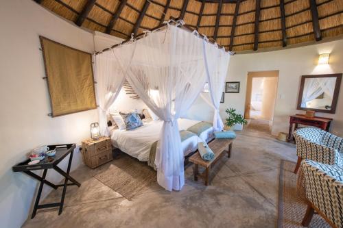a bedroom with a bed with a mosquito net at Nyala Safari Lodge in Hoedspruit