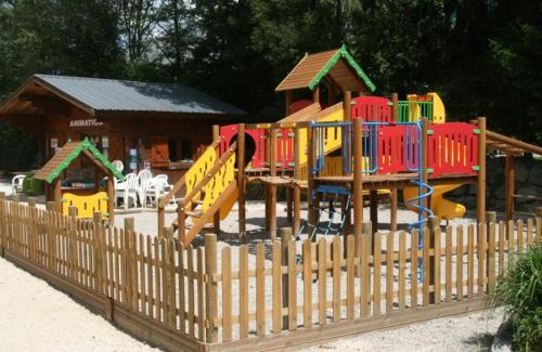 valla de madera con parque infantil frente a una casa en Camping Le Colporteur, en Le Bourg-dʼOisans