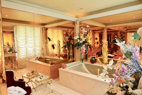 une grande salle de bain avec une baignoire et un lavabo dans l'établissement ARC de TRIOMPHE - FOCH PALACE, à Paris