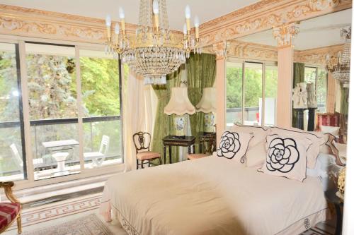 une chambre avec un lit et un lustre dans l'établissement ARC de TRIOMPHE - FOCH PALACE, à Paris