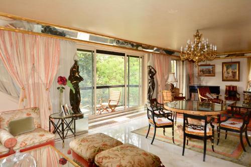 un salon avec une table et une salle à manger dans l'établissement ARC de TRIOMPHE - FOCH PALACE, à Paris
