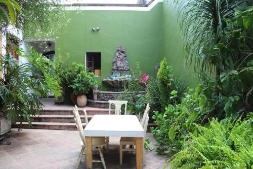 a table and chairs in a garden with plants at La Casa del Atrio in Querétaro