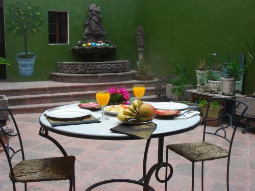 a table with a plate of food and two glasses at La Casa del Atrio in Querétaro