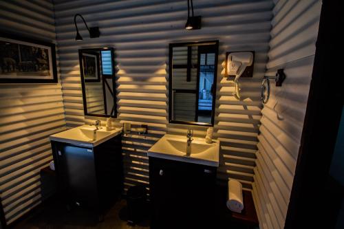a bathroom with two sinks and two mirrors at Lost & Found Hostels - Mandaramnuwara in Mandaran Newara